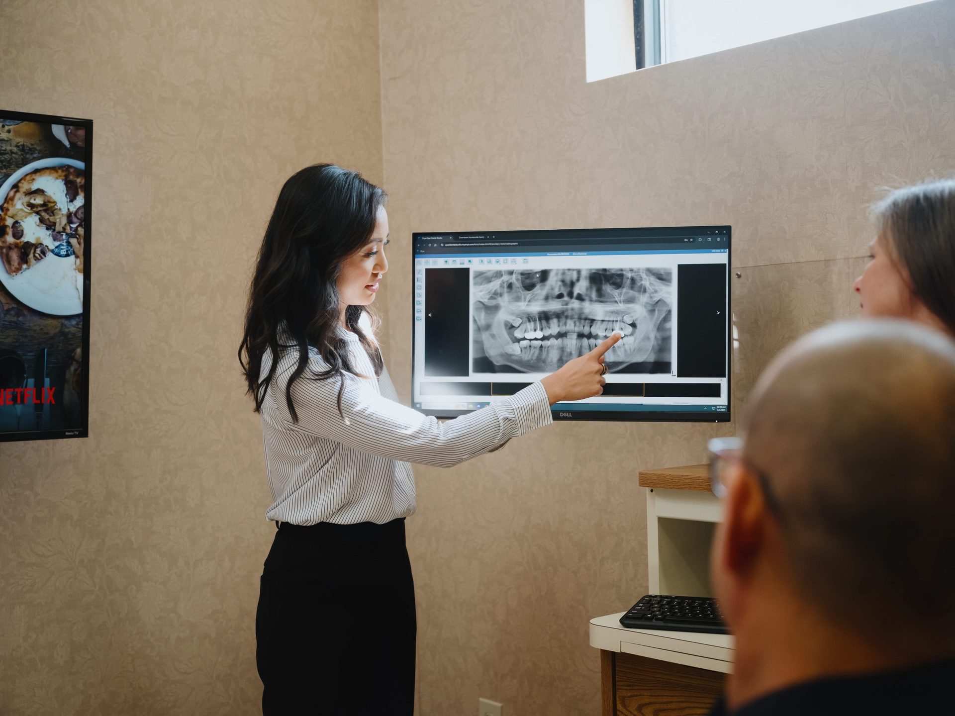 Dr. Abbey Gonzales reviewing a dental X-ray with a patient at Opal Dental Studio