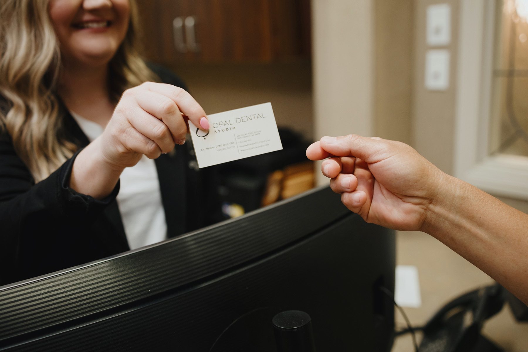 A membership card being handed across the front desk