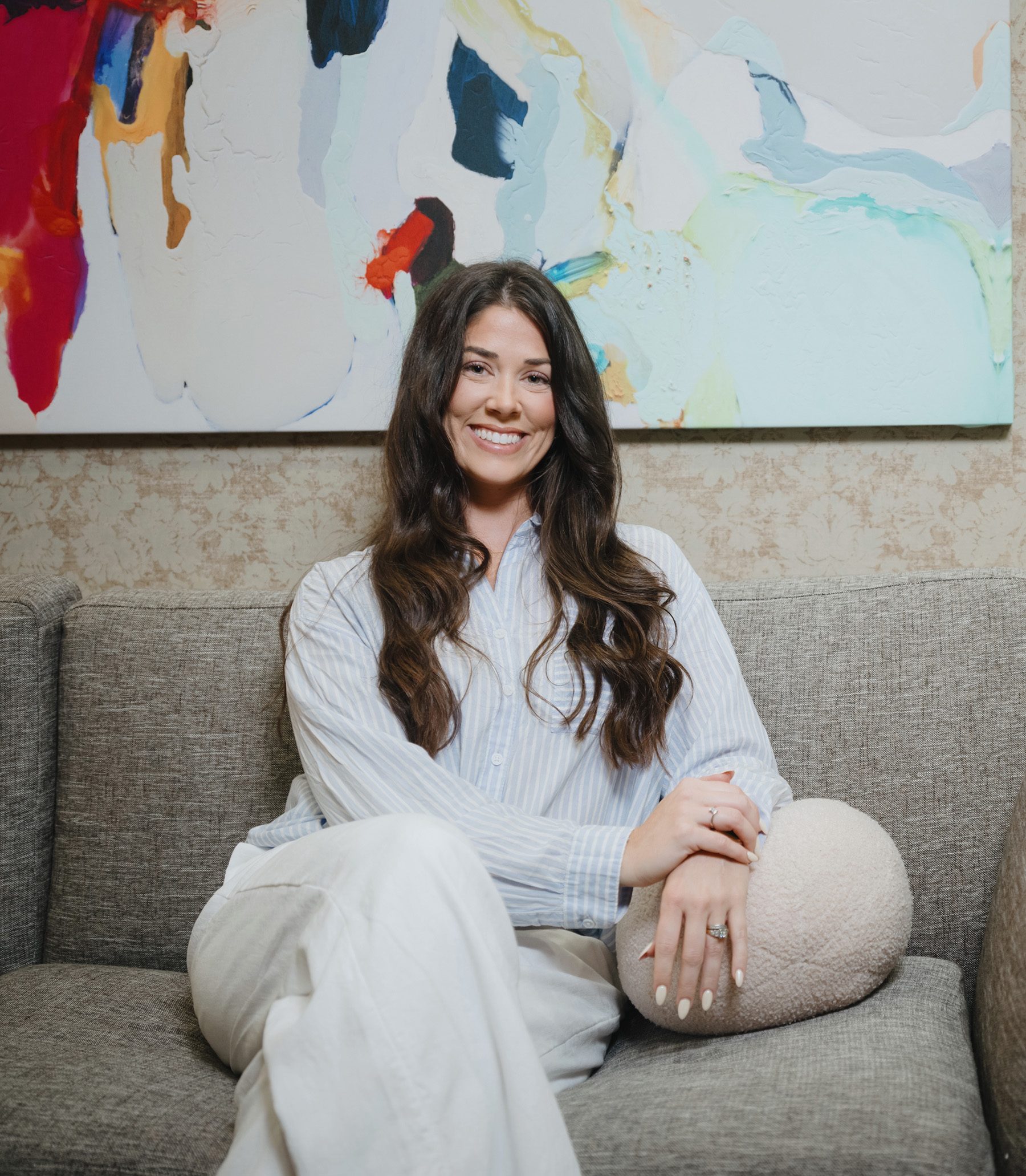 A patient seated on the lounge sofa in front of the studio’s abstract painting