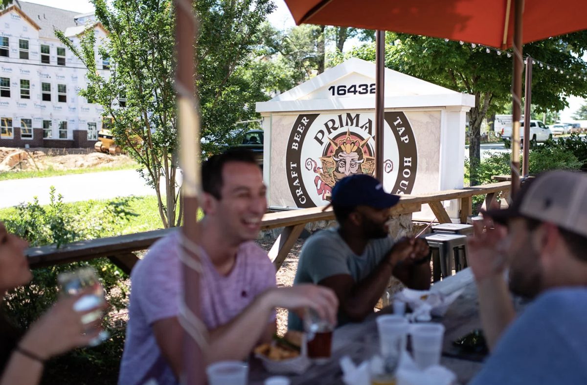Outdoor beer garden with picnic tables at Primal Brewery on Old Statesville Road in Huntersville, NC